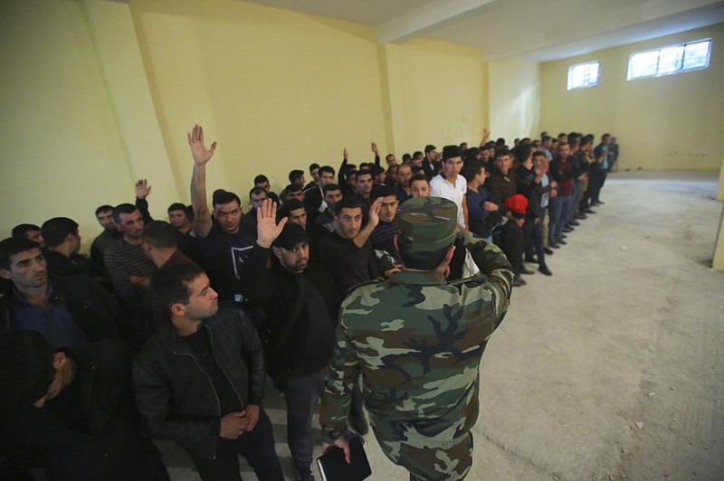 Azerbaijani men gather Wednesday to join the army in the Tartar region of Azerbaijan. More photos at arkansasonline.com/101clashes/.
(AP/Aziz Karimov)