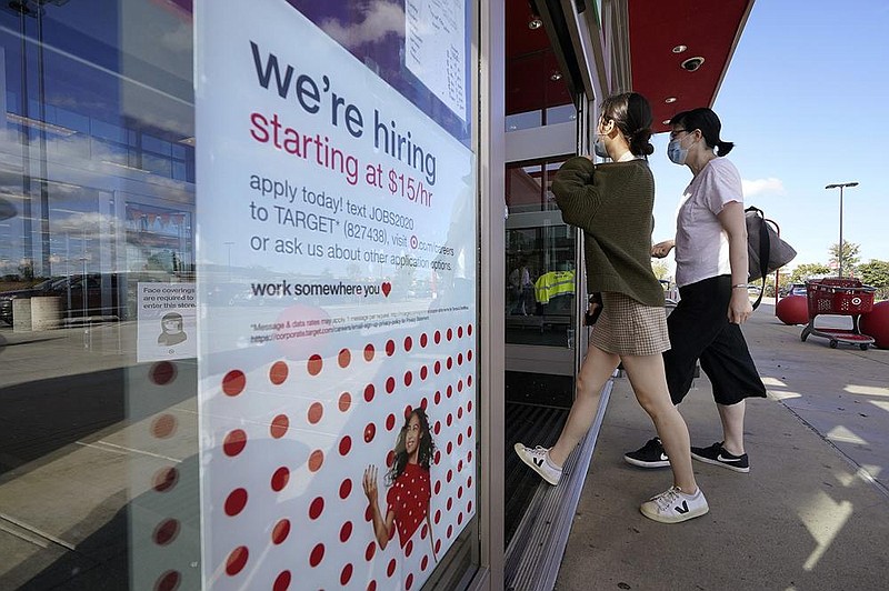 Shoppers pass a hiring sign Wednesday as they enter a Target store in Westwood, Mass. The number of Americans seeking unemployment benefits declined last week to a still-high 837,000.
(AP/Steven Senne)