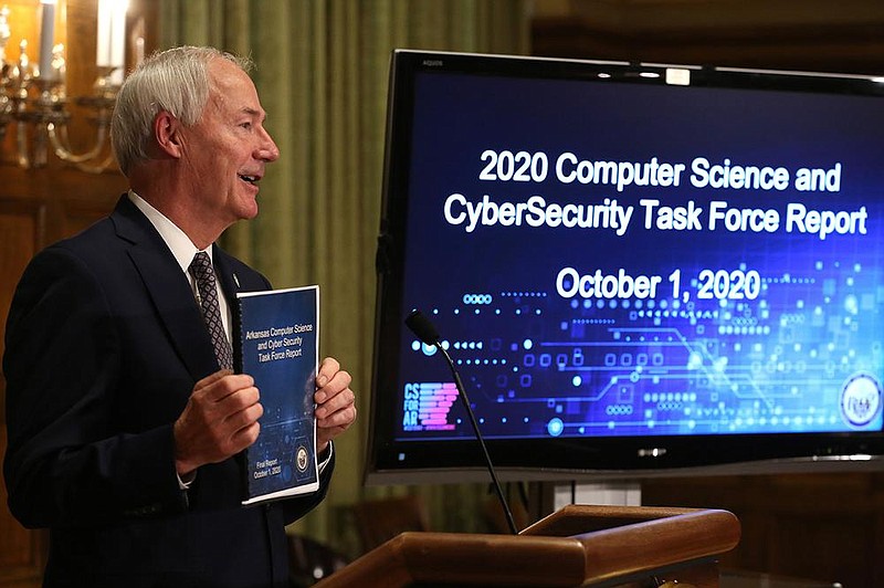 Gov. Asa Hutchinson shows the report from the 2020 Computer Science and CyberSecurity Task Force on Thursday during a news conference at the state Capitol. More photos at www.arkansasonline.com/102computer/.
(Arkansas Democrat-Gazette/Thomas Metthe)