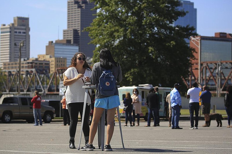 FILE — Azalea Andrade, left, and Cassie Exum eat lunch at the then-Verizon Arena VIP lot in North Little Rock during Food Truck Fridays in this Oct. 2, 2020 file photo. (Arkansas Democrat-Gazette/Staton Breidenthal)