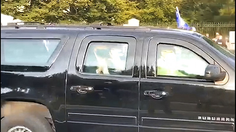In this image from video, President Donald Trump drives past supporters gathered outside Walter Reed National Military Medical Center in Bethesda, Md., on Sunday, Oct. 4, 2020. Trump was admitted to the hospital after contracting covid-19. (AP Photo/Phillip Crowther)
story.lead_photo.caption