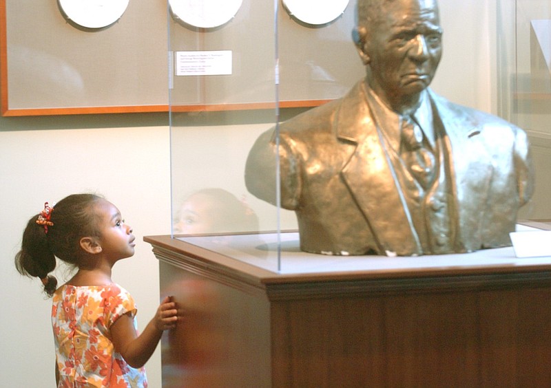 Asa Orneles of North Little Rock, then age 2, looks at the bust of Isaac Scott Hathaway, a Black artist and educator, in the Mosaic Templars Cultural Center and Museum at Little Rock in this 2008 file photo. (Arkansas Democrat-Gazette file photo)