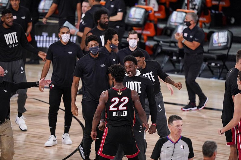 Bam Adebayo (center) congratulates Miami Heat’s Jimmy Butler after the Heat defeated the Los Angeles Lakers 115-104 in Game 3 of the NBA Finals on Sunday night.
(AP Photo/Mark J. Terrill)