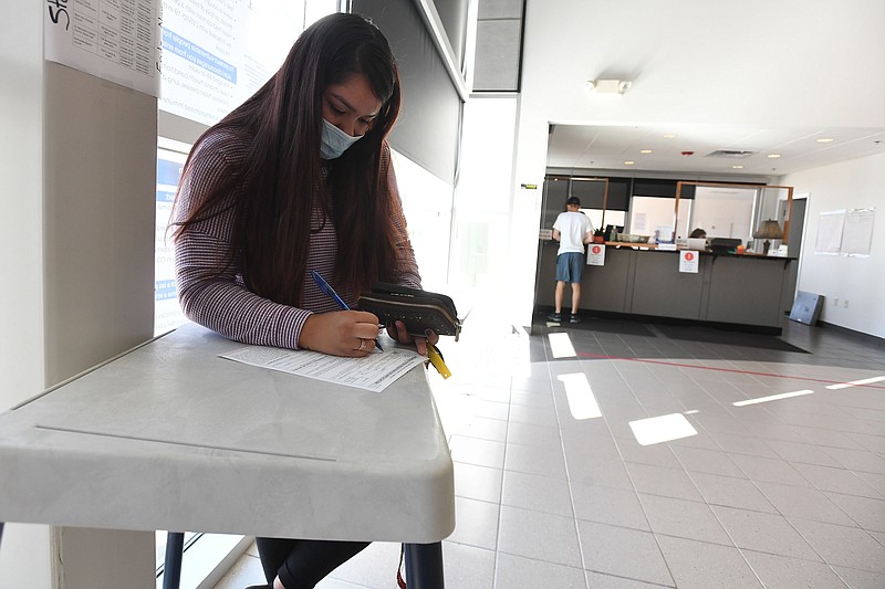 Nayeli Resendiz of Rogers  lls out her voter registration form Monday before turning it in at the Benton County Clerk’s office in Rogers. Monday was the last day to register to vote in the fall election. Early voting begins Oct. 19. For voter information in Benton County, go to vote.bentoncountyar.gov/ . Go to nwaonline.com/201006Daily/ and nwadg.com/photos for a photo gallery.
(NWA Democrat-Gazette/J.T. Wampler)