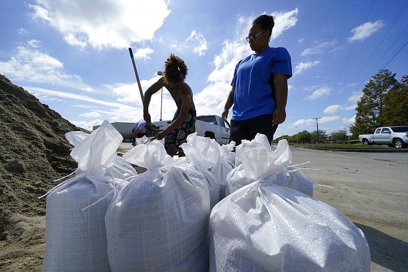 Stephanie Verrett and Jodie Jones fill sandbags to protect their home in anticipation of Hurricane Delta, expected to arrive along the Gulf Coast later this week, in Houma, La., Wednesday, Oct. 7, 2020. story.lead_photo.caption