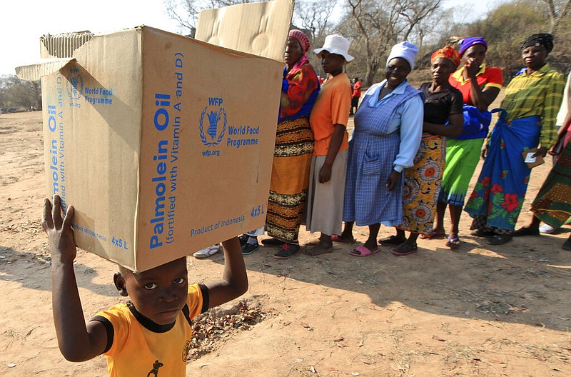 FILE - In this Sept. 9, 2015 file photo, a child carries a parcel from the United Nations World Food Program (WFP) in Mwenezi, Zimbabwe. The WFP has won the 2020 Nobel Peace Prize for its efforts to combat hunger and food insecurity around the globe. The announcement was made Friday Oct. 9, 2020 in Oslo by Berit Reiss-Andersen, the chair of the Nobel Committee. (AP Photo/Tsvangirayi Mukwazhi, File)


