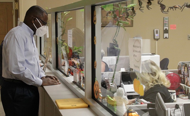 Stoney Shaw (left) of Pine Bluff pays his property tax bill at the Jefferson County Courthouse at Pine Bluff on Friday, Oct. 9, 2020, a few days ahead of the Oct. 15 deadline. Deputy Tax Collector Rebekah Collins helps Shaw complete the transaction.