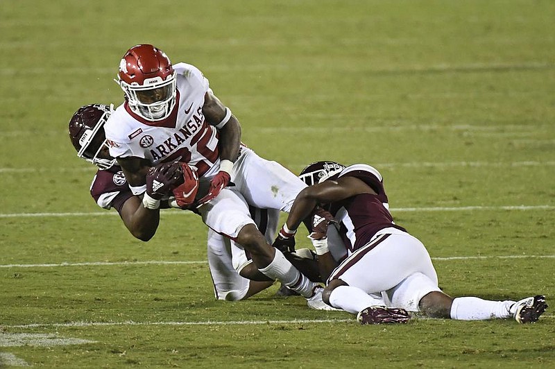 Arkansas running back Trelon Smith (22) is dragged down during the Razorbacks’ victory over Mississippi State in Starkville, Miss.,  last week. The Razorbacks’ running game has struggled this season, averaging 70.0 yards per game. Auburn, the Hogs’ opponent  today, has similar issues, averaging 65.0 rushing yards per game.
(AP/Thomas Graining)