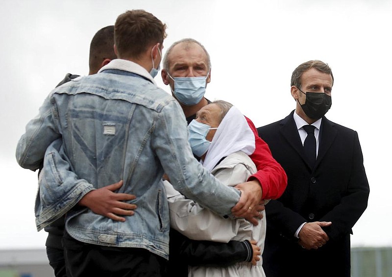 French President Emmanuel Macron stands nearby Friday as Sophie Petronin (center right), a French aid worker held hostage for four years by Islamic extremists in Mali, is greeted by relatives upon her arrival back in France. More photos at arkansasonline.com/1010petronin/.
(AP/Gonzalo Fuentes)