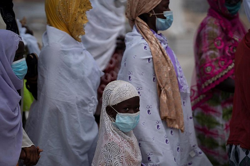 Wearing a protective mask, a girl looks at the camera, as she stands in line to enter the Grand Mosque of Touba on Monday as part of the celebrations of the Grand Magal of Touba, Senegal. Despite the coronavirus pandemic, thousands of people from the Mouride Brotherhood, an order of Sufi Islam, gathered for the annual religious pilgrimage to celebrate the life and teachings of Cheikh Amadou Bamba, the founder of the brotherhood.
(AP/Leo Correa)