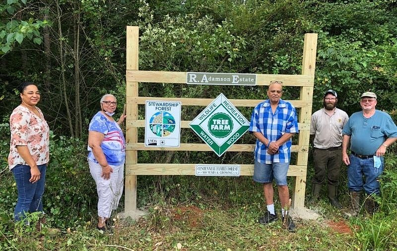 Participants in the "Keeping It In The Family" Sustainable Forestry and African American Land Retention program at the University of Arkansas at Pine Bluff hold a ceremony to install a sign that recognizes land owned by the Adamson family as a certified American Tree Farm. From left are Kandi Williams, UAPB-KIITF outreach coordinator; Helen Adamson, an estate owner; Shawn Boler, executor of the land; Justin Mallett, KIITF program partner; and Joe Friend, UAPB forester.