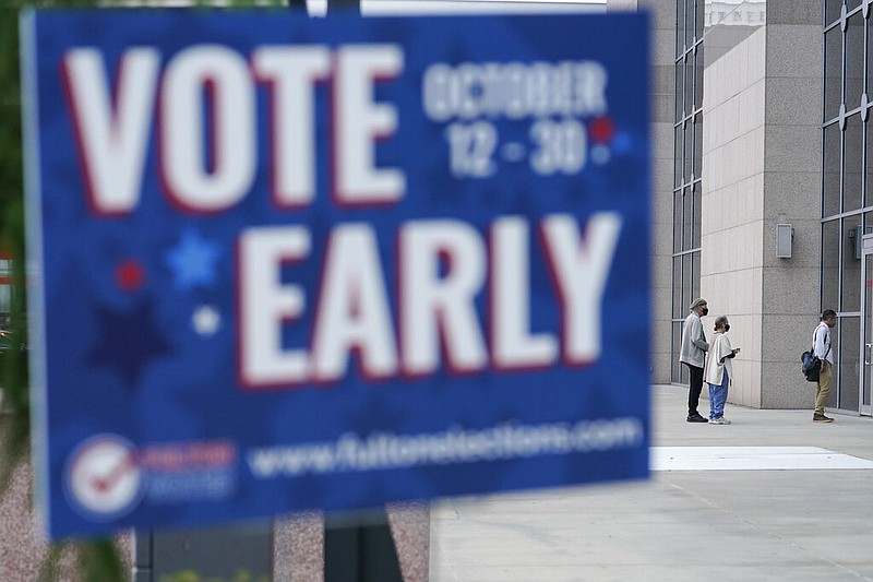 A line forms outside of the State Farm Arena for early voting on Monday, Oct. 12, 2020, in Atlanta.