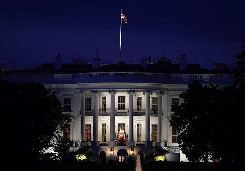 FILE - In this Oct. 5, 2020, file photo an American flag files atop the White House after President Donald Trump arrived from Walter Reed National Military Medical Center via Marine One in Washington.