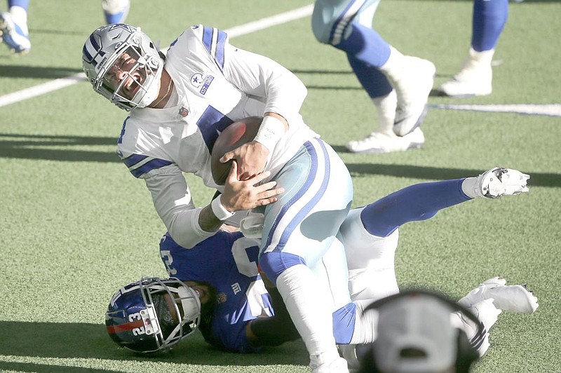 Dallas quar- terback Dak Prescott is tackled by NewYork Giants corner- back Logan Ryan (rear) 
in the sec- ond half of the Cowboys’ 37-34 victory Sunday in Arlington, Tex- as. Prescott suffered a right ankle injury on the play, left the game and was due to have surgery Sunday night. (AP/Michael Ainsworth) 