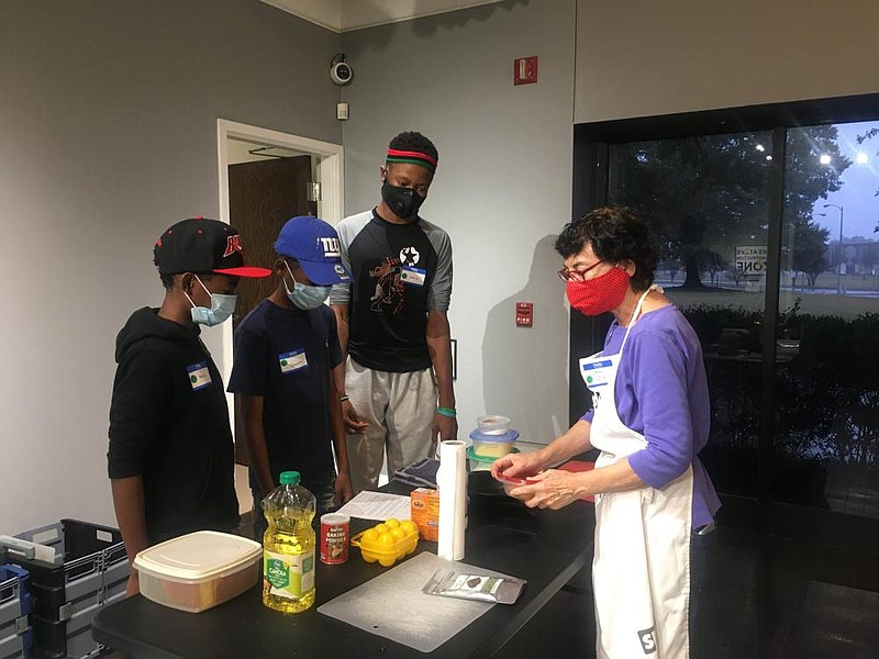 CrEATe Lab cooking workshop instructor and cooking expert Faith Anaya (right) introduces the Adams brothers, Cedric (right), Quentin (center) and Mekhi (left) to skillet cornbread. (Special to The Commercial/Deborah Horn) story.lead_photo.caption