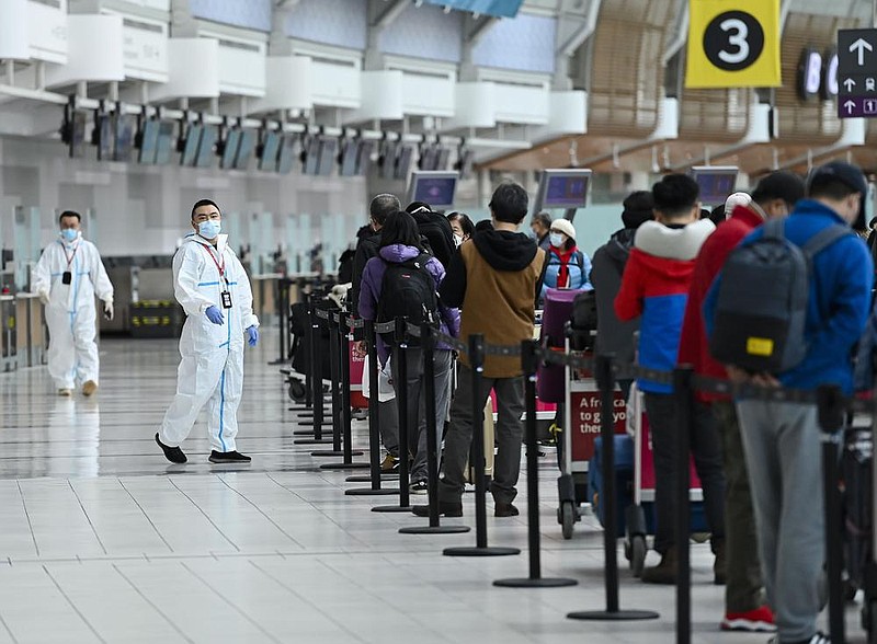 People line up Wednesday to board an international flight at the airport in Toronto. Canadian Prime Minister Justin Trudeau closed Canada’s international borders to nonessential travel in March. (AP/The Canadian Press/Nathan Denette) 
