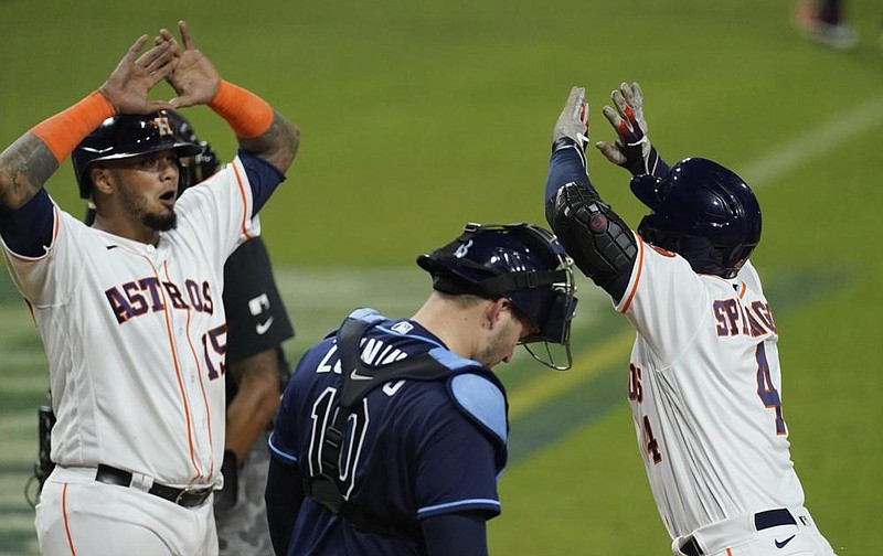 Houston’s George Springer (right) celebrates with teammate Martin Maldonado after hitting a two-run home run Wednesday during the fifth inning of the Astros’ 4-3 victory over the Tampa Bay Rays in Game 4 of the American League Championship Series at Petco Park in San Diego. (AP/Ashley Landis) 