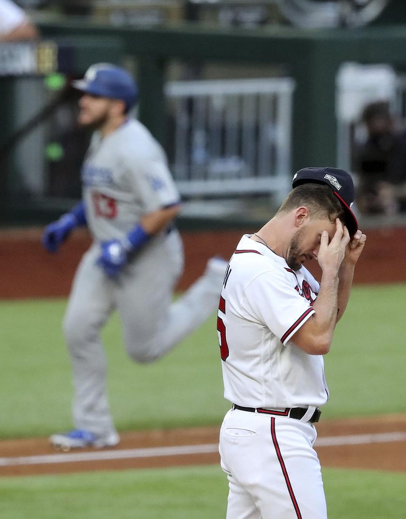 Atlanta reliever Grant Dayton (right) tries to collect himself Wednes- day as Los Angeles first baseman Max Muncy rounds third base after hitting a grand slam in an 11-run first inning that helped the Dodgers beat the Braves 15-3 in Game 3 of the National League Championship Series in Arlington, Texas. 
(AP/Atlanta Journal-Constitution/Curtis Compton) 