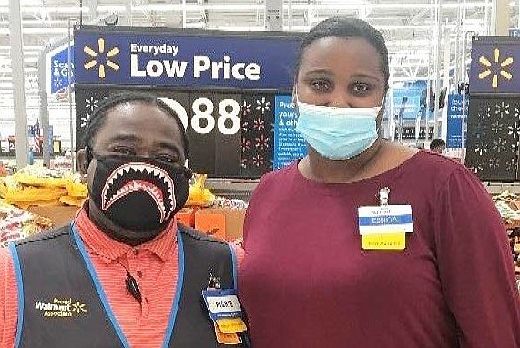 Essica Clifton (right), manager of the Pine Bluff Walmart, is shown with an associate during the presentation of $2,000 worth of school supplies and uniform shirts to the Pine Bluff School District.