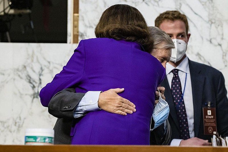Sen. Dianne Feinstein hugs Senate Judiciary Chairman Lindsey Graham on Thursday at the close of the confirmation hearing for Supreme Court nominee Amy Coney Barrett. She praised him for his fairness. More photos at arkansasonline.com/1016hearing/.
(AP/Samuel Corum)