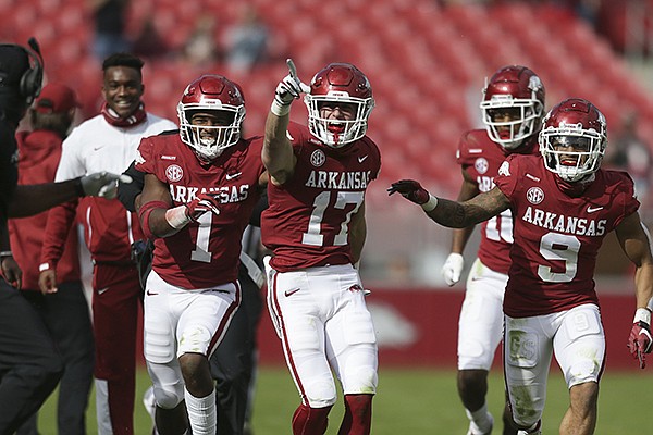 Arkansas defensive backs Hudson Clark (17), Jalen Catalon (1) and Greg Brooks (9) celebrate after Clark intercepted a pass during a game against Ole Miss on Saturday, Oct. 17, 2020, in Fayetteville. All three players had at least one interception and the Razorbacks intercepted six passes in their 33-21 victory over the Rebels.