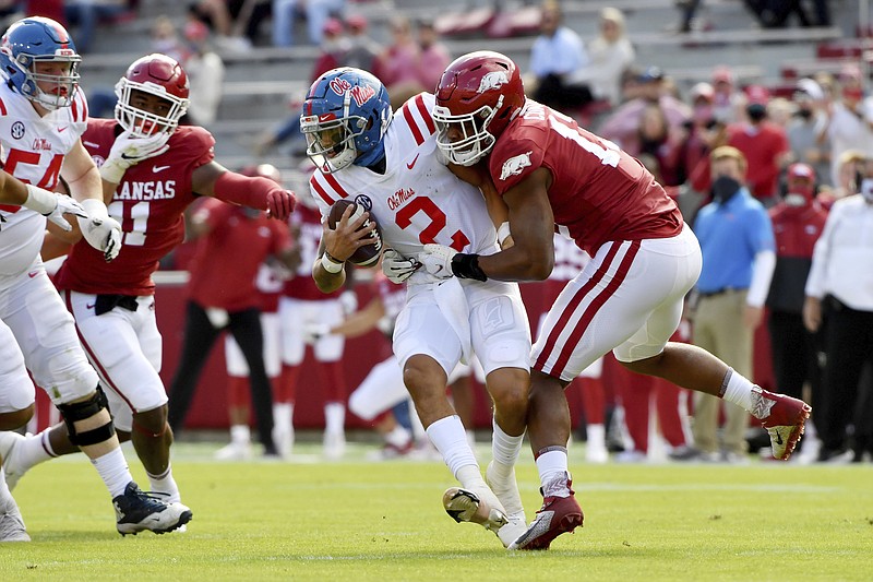 Arkansas defensive lineman Julius Coates (13) tackles Mississippi quarterback Matt Corral (2) for a loss during the first half of an NCAA college football game Saturday, Oct. 17, 2020, in Fayetteville, Ark. (AP Photo/Michael Woods)