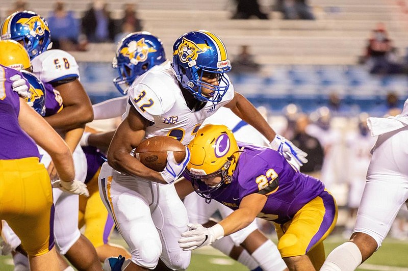 North Little Rock running back Aaron Sims (left) tries to cut past Little Rock Catholic’s Drew Parker during Friday night’s game at War Memorial Stadium in Little Rock. (Arkansas Democrat-Gazette/Justin Cunningham)