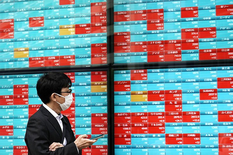 A man checks out stock data for Japan’s Nikkei 225 index on an electronic board at a securities firm Friday in Tokyo.
(AP/Eugene Hoshiko)