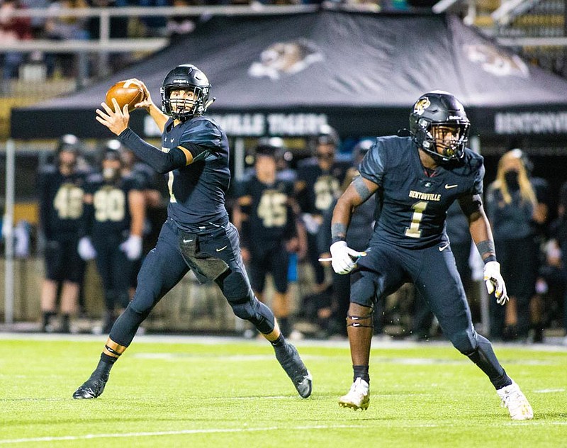 Andrew Edwards (left) scrambles during Bentonville’s 59-14 drubbing of Fayetteville on Friday at Tiger Stadium in Bentonville. Edwards threw for four touchdowns. More photos at arkansasonline.com/1017bentonville/.
(Special to NWA Democrat-Gazette/ David Beach)