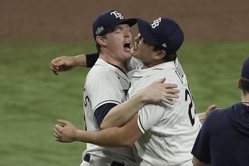 Tampa Bay Rays teammates Peter Fairbanks (left) and Ji-Man Choi celebrate after Saturday night’s victory over the Houston Astros  in Game 7 of the American League Championship Series. The Rays advanced to the World Series.
(AP/Ashley Landis)