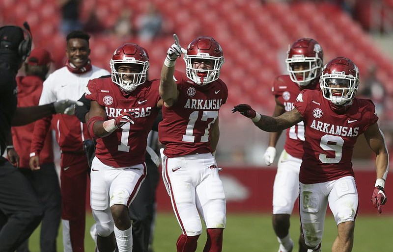 Arkansas defensive back Hudson Clark (17) celebrates with Jalen Catalon (1) and Greg Brooks Jr. (9) in the third quarter after the second of his three interceptions Saturday against Ole Miss in Fayetteville. All three contributed to the Hogs’ six interceptions during a 33-21 victory. More photos at arkansasonline.com/1018razorbacks.
(NWA Democrat-Gazette/Charlie Kaijo)
