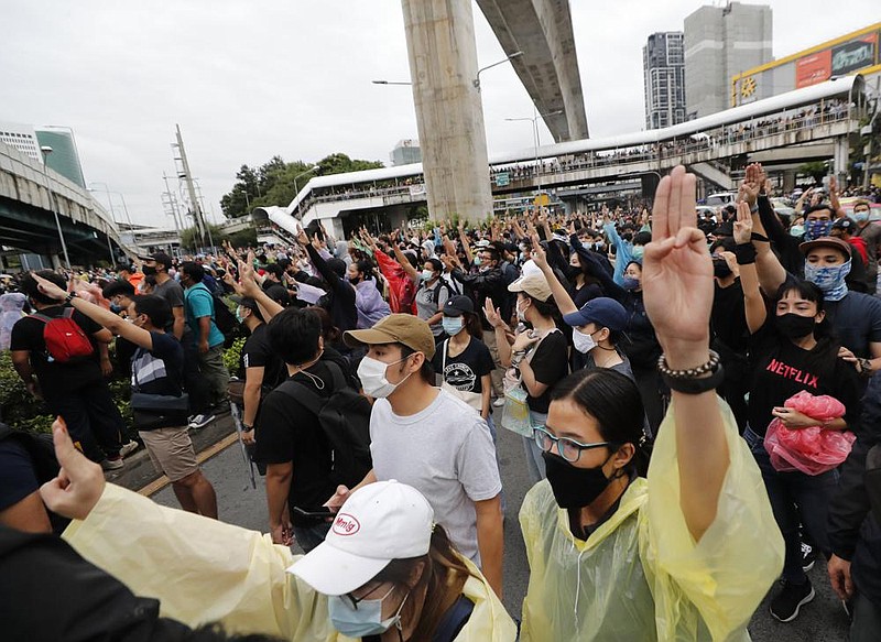 Pro-democracy demonstrators raise three fingers, considered a symbol of resistance, during a protest Saturday near a train station in Bangkok. More photos at arkansasonline.com/1018thailand/.
(AP/Sakchai Lalit) story.lead_photo.caption