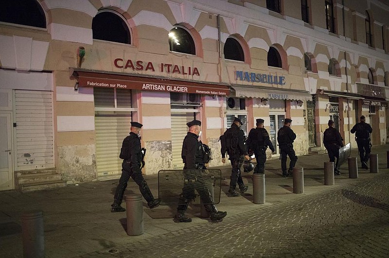 Police officers enforce a curfew Saturday in Marseille in southern France. France is deploying 12,000 police officers to enforce a new curfew that took effect Friday night.
(AP/Daniel Cole)