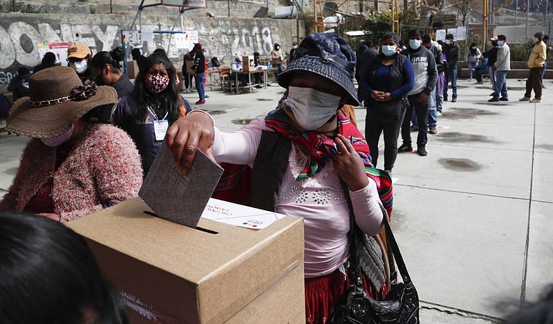 A woman casts her vote during general elections in La Paz, Bolivia, Sunday, Oct. 18, 2020. (AP Photo/Juan Karita)