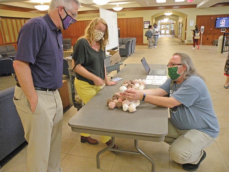 Liz Smith, University of Central Arkansas associate professor of ceramics, center, explains the Acorn Project to UCA President Houston Davis, left, and Carl Olds, academic director of Short and Denney residence halls, following the kickoff celebration of the Suffrage Centennial Celebration on Aug. 26 at UCA.