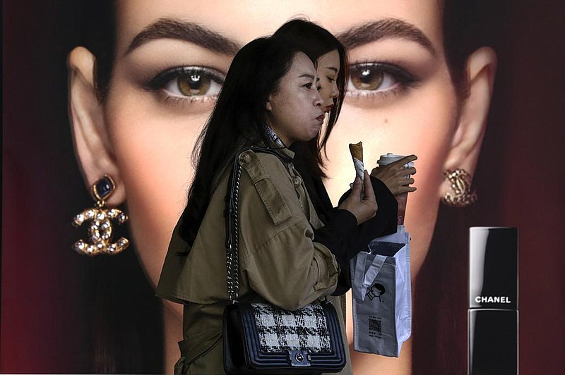 Women pass a Chanel cosmetic shop Monday at a Beijing shopping mall. China’s shaky economic recovery from the coronavirus pandemic is gaining strength. (AP/Andy Wong) 