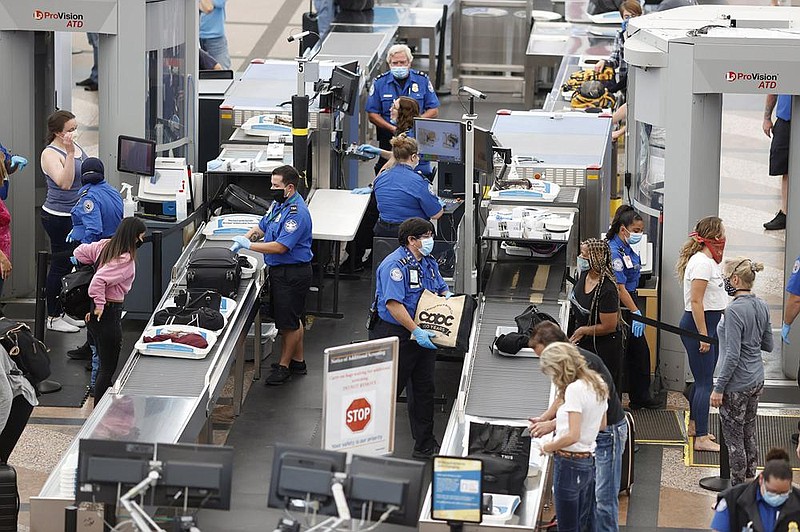 Transportation Security Administration agents check passengers at Denver International Airport in this June file photo. TSA, the government agency that oversees air travel, said the daily number of passengers screened for flights topped 1 million on Sunday for the first time since the coronavirus pandemic outbreak last March. 
(AP) 