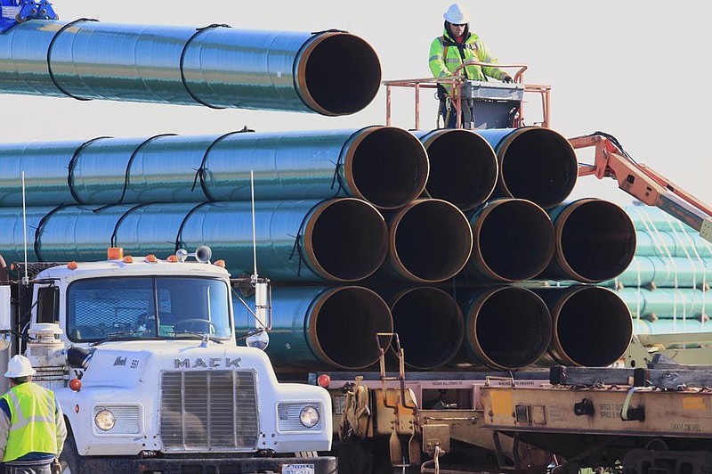 Workers unload pipe in Worthing, S.D., for the Dakota Access oil pipeline in 2015. American Indian tribes opposed to the pipeline have asked a federal judge to halt it. (AP) 