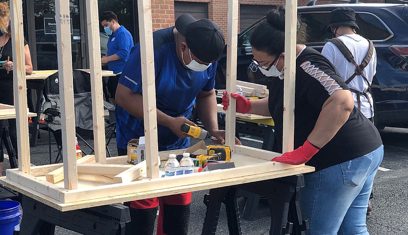 Al Berrellez, builds a desk in Gaithersburg, Md., on Sept. 25. Jessica and Al Berrellez, with the help of some 60 community volunteers, have built and donated over 100 desks so far to students and families in need. (Jessica Berrellez via AP)