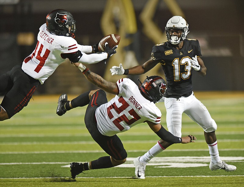 Arkansas State defensive back Antonio Fletcher (left) intercepts a pass intended for Appalachian State wide receiver Christian Horn (right) during the first half of their NCAA college football game at Kidd Brewer Stadium in Boone, N.C., on Thursday, Oct. 22, 2020. ASU linebacker Caleb Bonner is in the center.