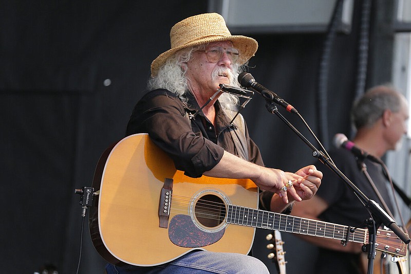 Arlo Guthrie talks during a concert at a Woodstock 50th anniversary event in Bethel, N.Y., in this Aug. 15, 2019, file photo. The 73-year-old folksinger announced Friday, Oct. 23, 2020, that he is retiring from performing, effective immediately.