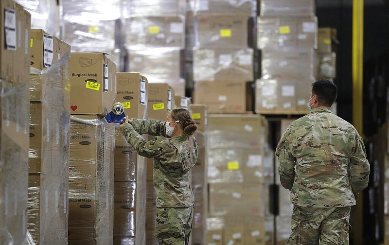 Members of the National Guard work with personal protective equipment during the coronavirus pandemic at a San Antonio warehouse in this Aug. 4, 2020, file photo. The Arkansas National Guard said Friday, Oct. 23, 2020, that 39 Arkansas guardsmen are on active duty providing pandemic assistance.