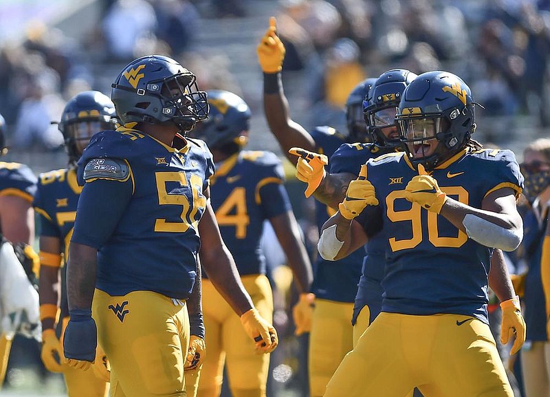 West Virginia defensive lineman Darius Stills (56) celebrates with teammates after intercepting a pass in last week’s game against Kansas in Morgantown, W.Va. In a conference best known in recent years for high-scoring showdowns and crazy passing numbers, the Big 12 now boasts some of the nation’s stingiest defenses.
(AP/The Dominion-Post/William Wotring)