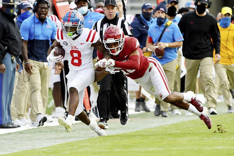 Ole Miss receiver Elijah Moore (left) is knocked out of bounds by Arkansas defensive back Myles Mason during the second half Saturday in Fayetteville. Mason had nine tackles and a half-tackle for loss in his best performance as a Razorback.
(AP/Michael Woods)