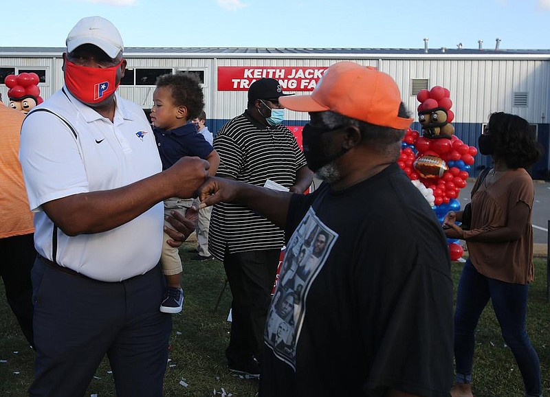 Former NFL standout and Little Rock Parkview alum Keith Jackson (left) is congratulated by his former Sunset coach, McKinley “Coach June” Johnson, after a fieldhouse dedication ceremony in his honor Thursday at Parkview. See more photos at arkansasonline.com/1023jackson/
(Arkansas Democrat-Gazette/Thomas Metthe)
