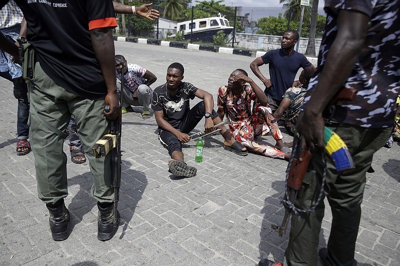 Police officers stop and search a bus carrying passengers around Lekki toll gate in Lagos Friday, Oct. 23, 2020. Resentment lingered with the smell of charred tires Friday as Nigeria’s streets were relatively calm after days of protests over police abuses, while authorities gave little acknowledgment to reports of the military killing at least 12 peaceful demonstrators earlier this week.