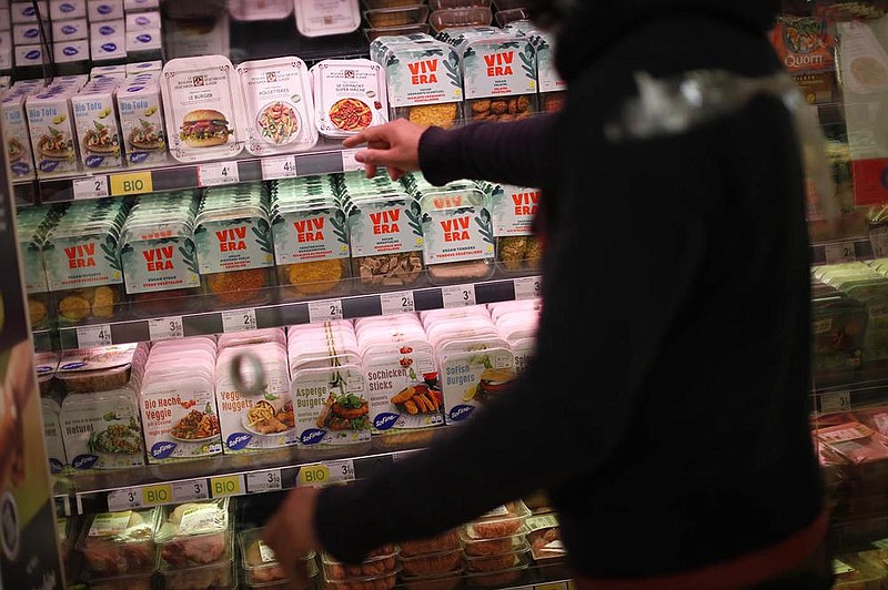 A clerk points out plant-based products Friday at a supermarket in Brussels, where European lawmakers have decided that products that don’t contain meat can still be sold as meat. 
(AP/Francisco Seco)