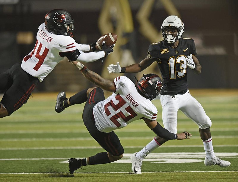 Arkansas State defensive back Antonio Fletcher (left) intercepts a pass intended for Appalachian State wide receiver Christian Horn in the first half Thursday at Kidd Brewer Stadium in Boone, N.C. ASU’s defense gave the Red Wolves’ offense some chances to stay in the game, but ASU ended up losing 45-17.
(AP/Winston-Salem Journal/Walt Unks)