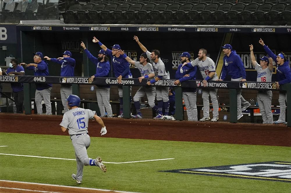 Los Angeles catcher Austin Barnes (15) rounds the bases Friday as teammates cheer his home run during the sixth inning of the Dodgers’ 6-2 victory over the Tampa Bay Rays in Game 3 of the World Series at Globe Life Field in Arlington, Texas.
(AP/Tony Gutierrez)