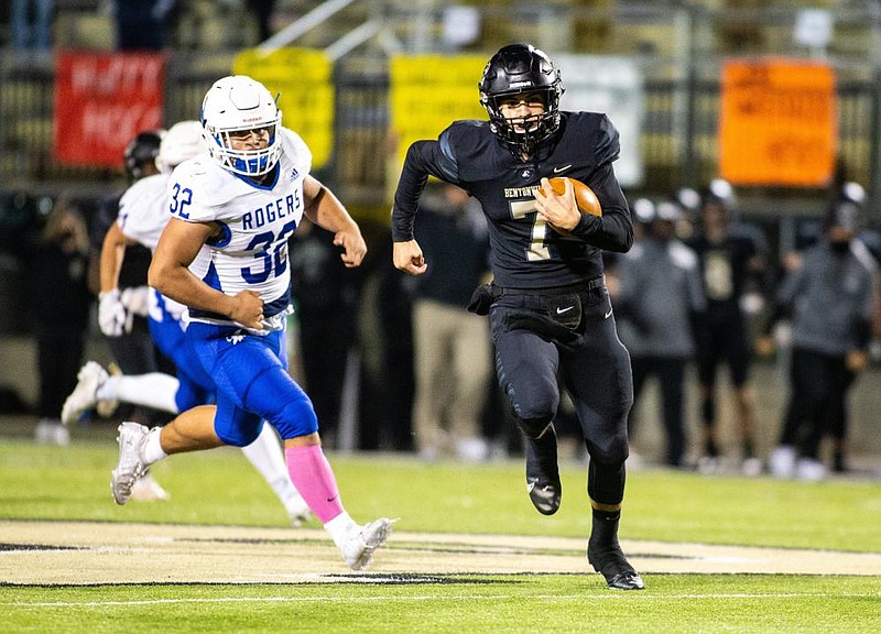 Andrew Edwards (right) of Bentonville runs for a 63-yard touchdown — one of six scores the senior quarterback had a hand in Friday — as the Tigers broke a single-game school scoring record in a 74-21 victory over Rogers at Tiger Stadium in Bentonville. More photos at arkansasonline.com/1024rogers/
(Special to NWA Democrat-Gazette/David Beach)